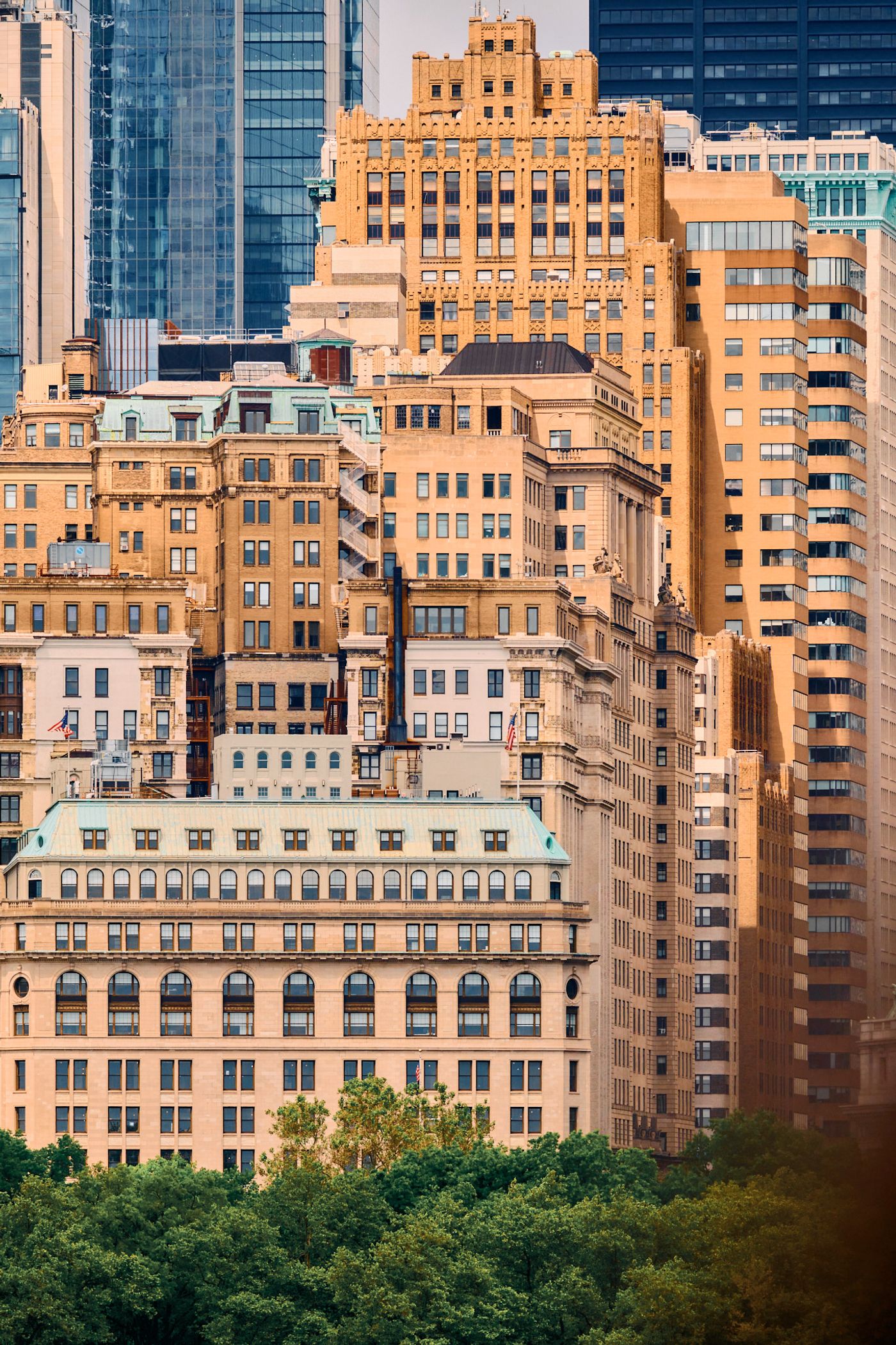 A bustling cityscape with tall buildings, a mix of modern and older architecture, and a park in the foreground.