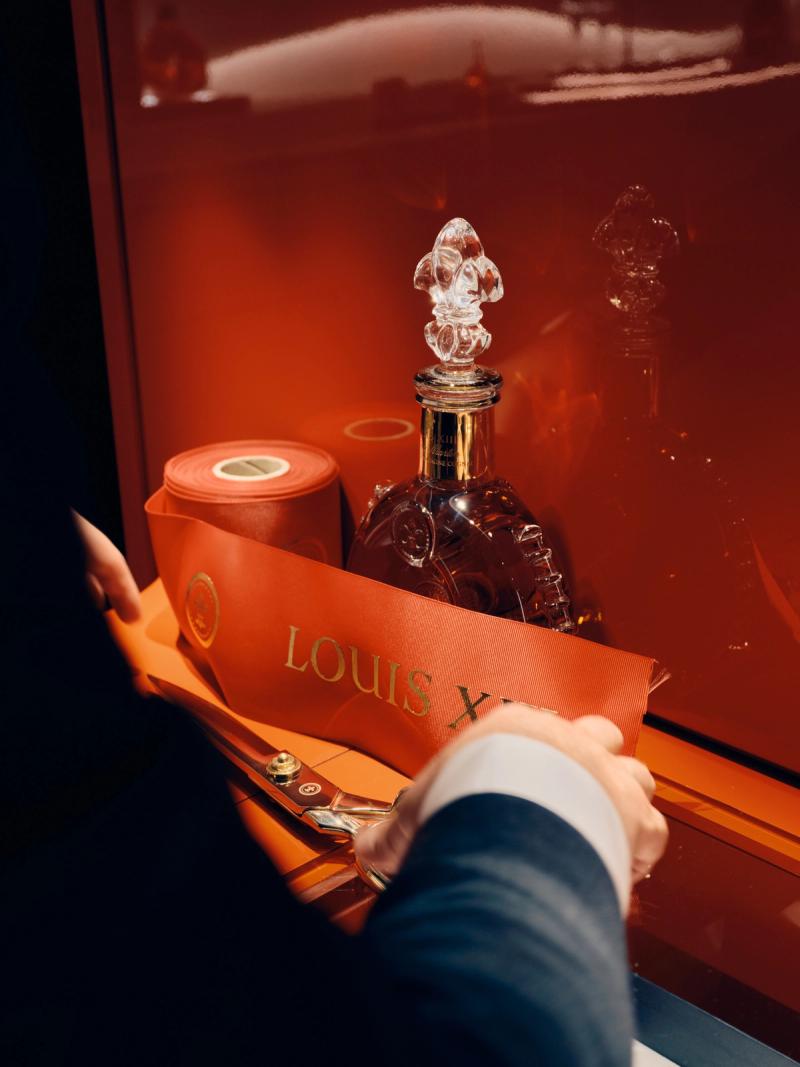 Close-up of cognac being poured into champagne flutes at a wedding toast