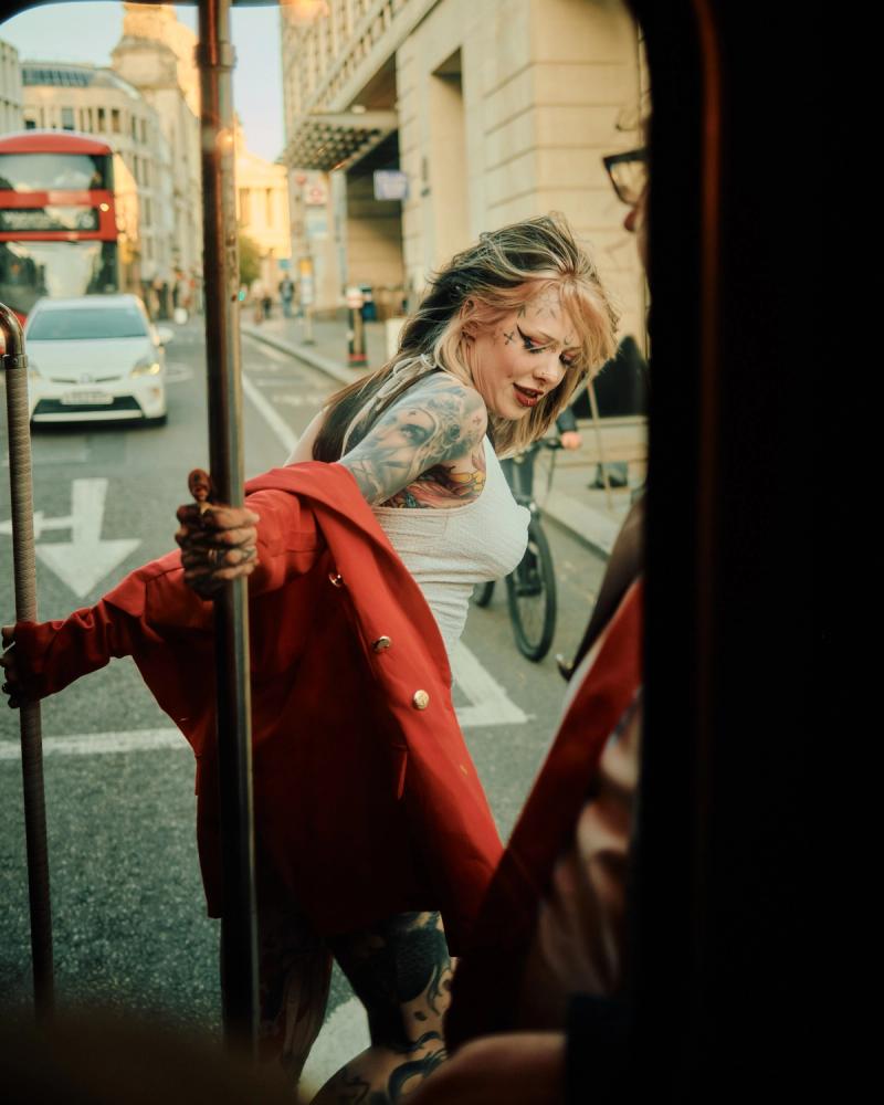 Woman leaning across a train-style red seat in a lifestyle portrait