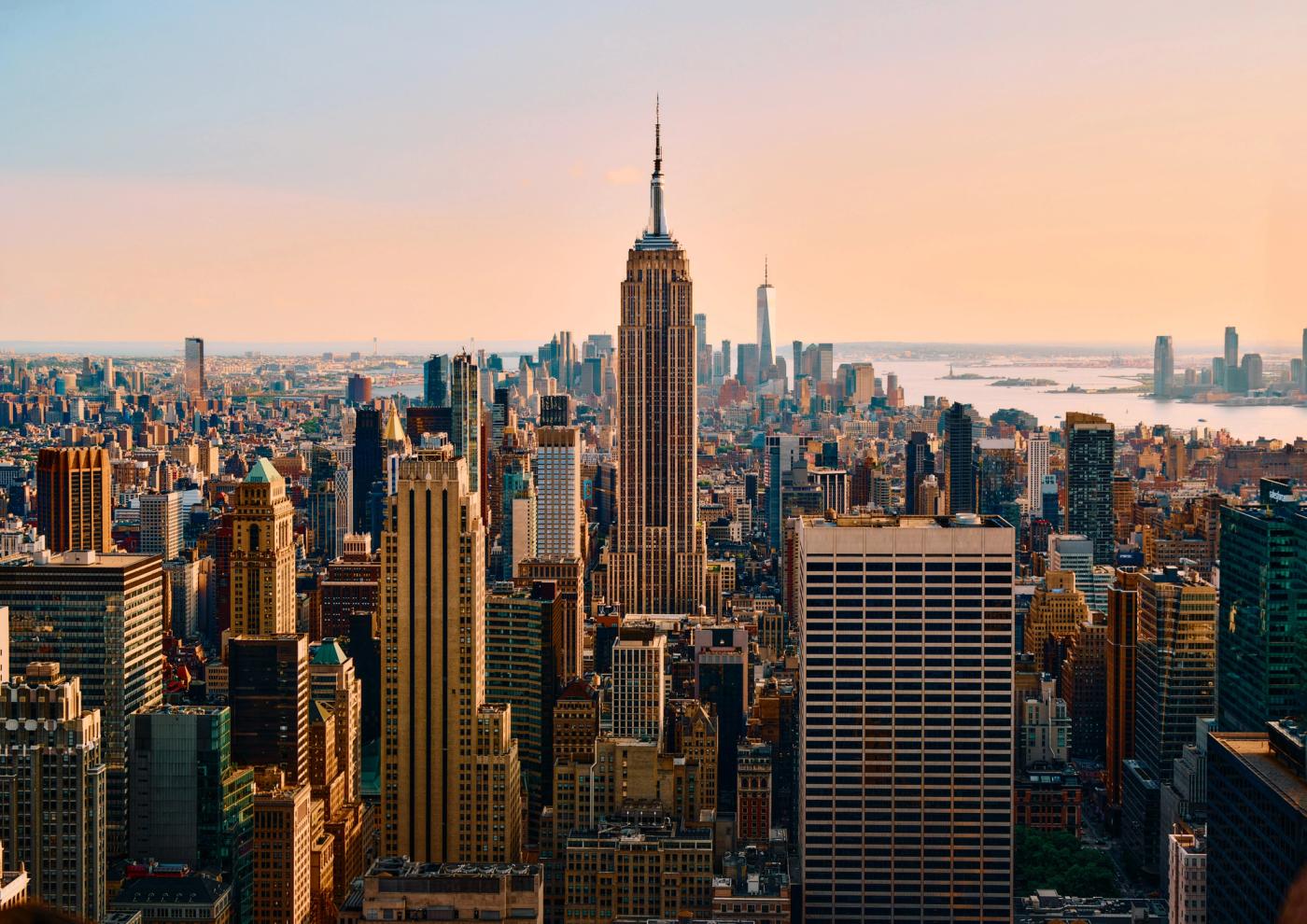The image showcases the iconic Empire State Building in New York City, with its brown and beige facade and spire reaching towards the sky. The citysca