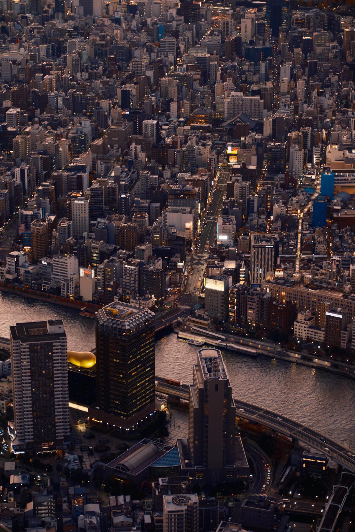 Aerial sunset view of Manhattan skyline at dusk with East River bridges and city lights, New York City urban architecture photography