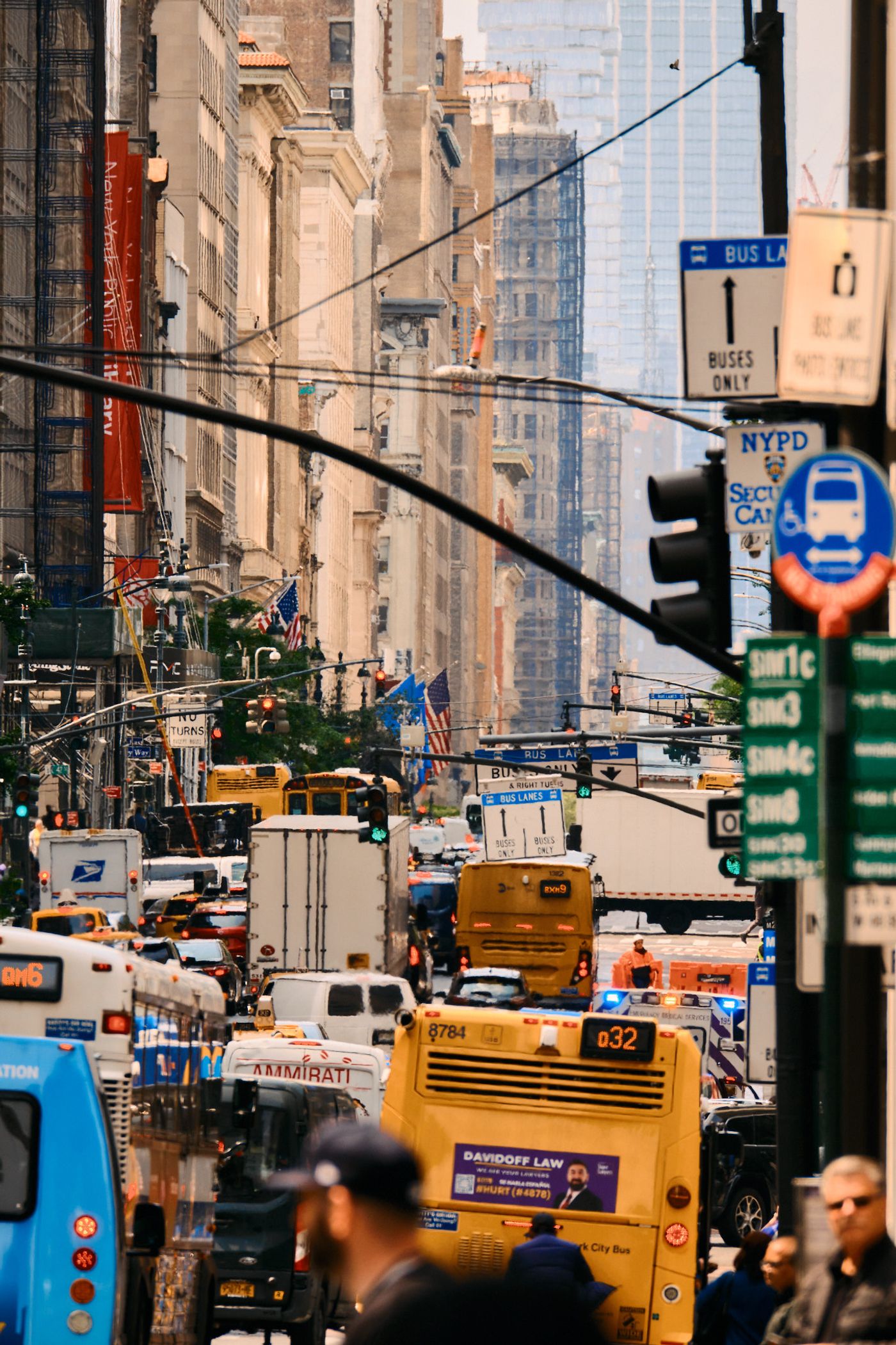 A bustling New York City street filled with vehicles, pedestrians, and towering buildings.
