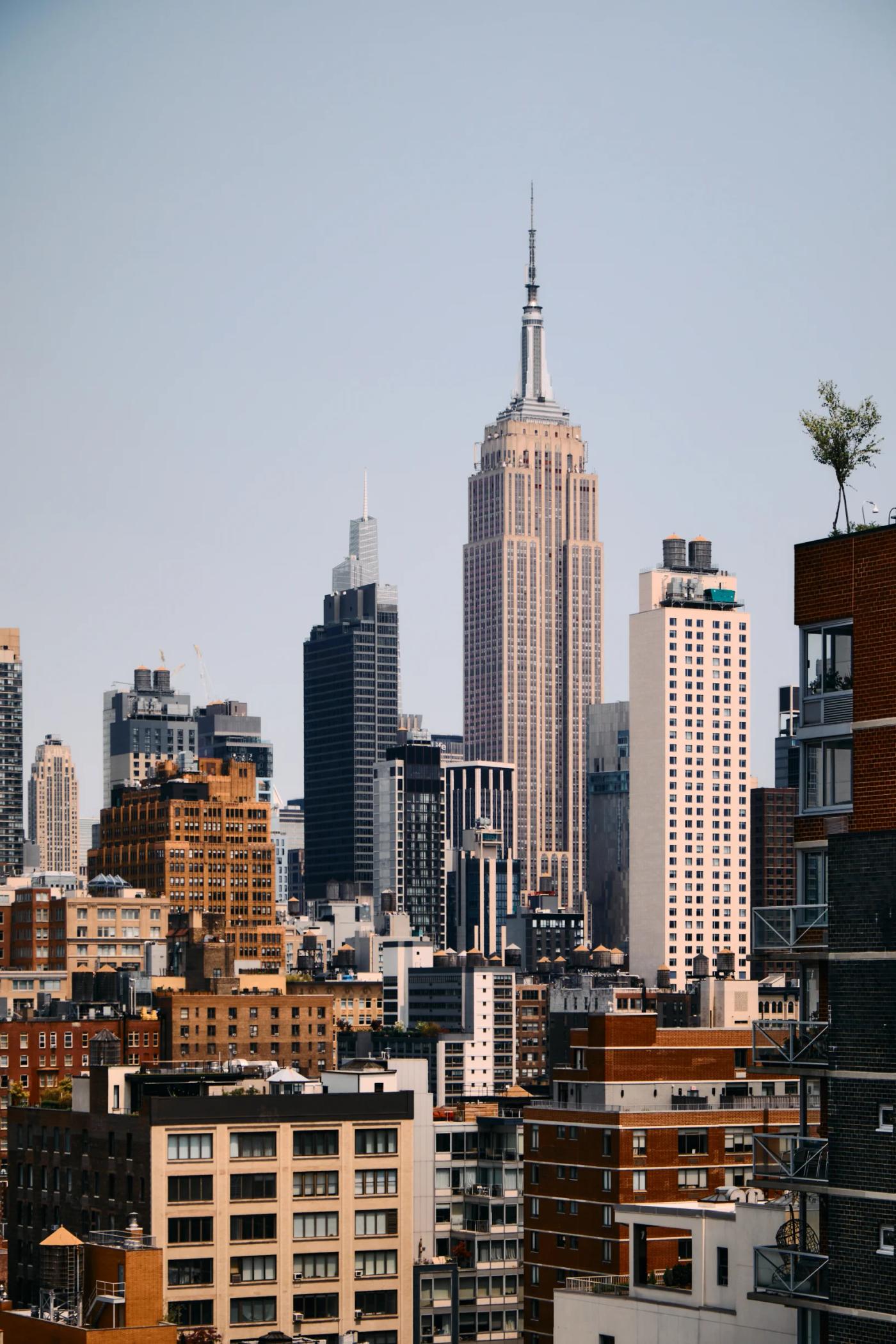 The Empire State Building is prominently featured in a cityscape, with its white and gray color scheme and spire reaching towards the sky. The photo i