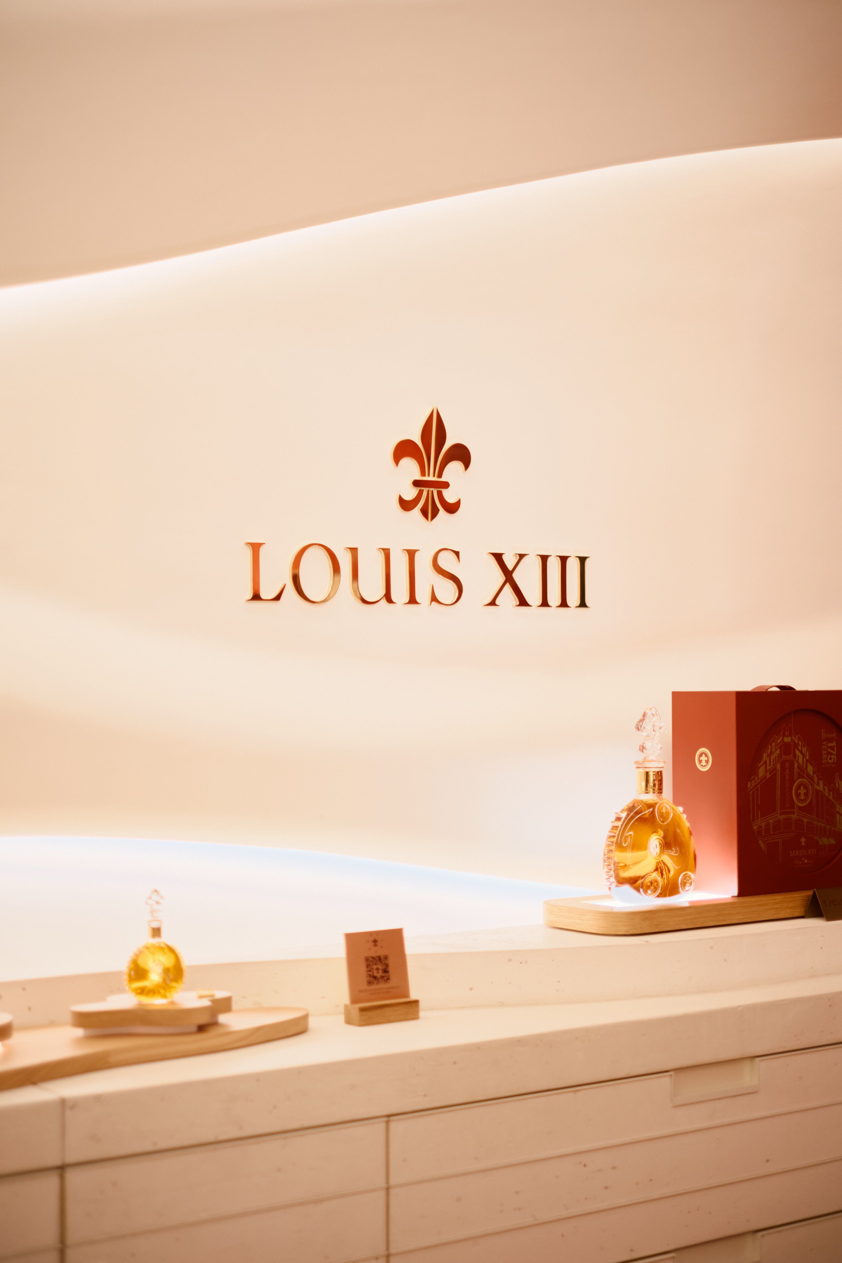 Louis XIII luxury cognac signage in store with decanter and soft lighting in a modern interior design environment