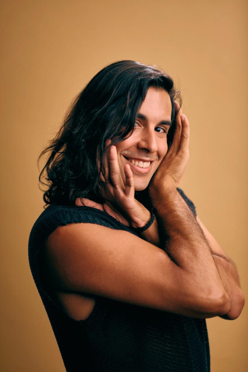 Headshot portrait of a young man with natural expression in studio light