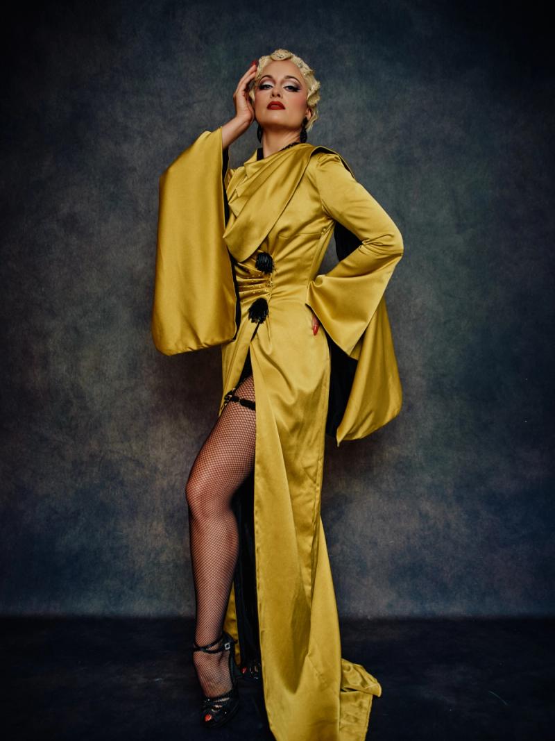 Fashion portrait of a model in a bold gold couture dress with strong lines