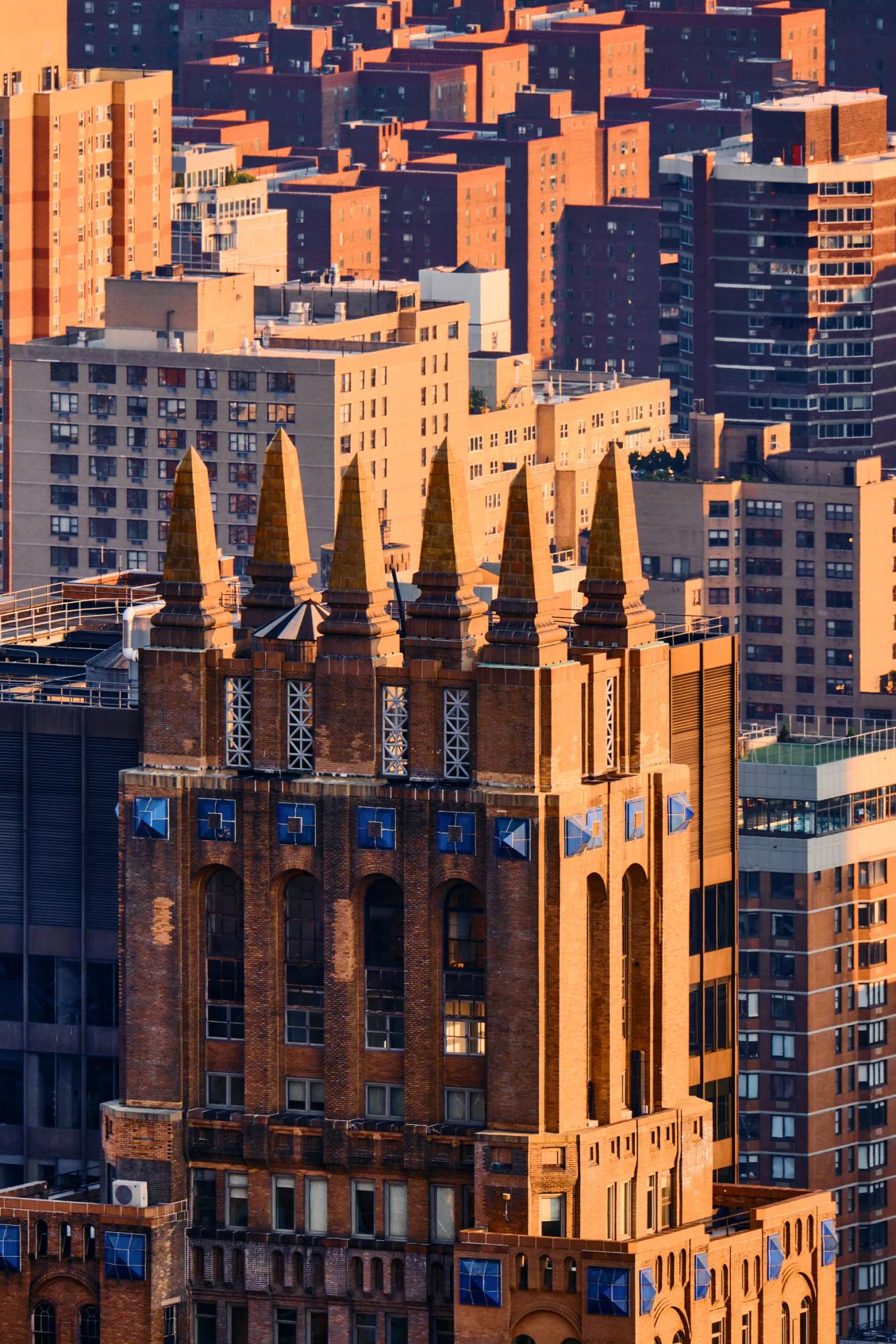 A cityscape with a prominent clock tower, surrounded by other buildings and a clear sky.
