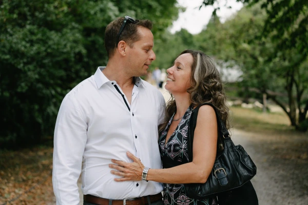 Middle-aged couple looking at each other lovingly outdoors during a wedding event.