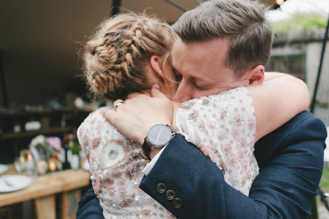 Bride and groom hugging intimately during the wedding ceremony in rustic romantic outdoors venue in Edinburgh