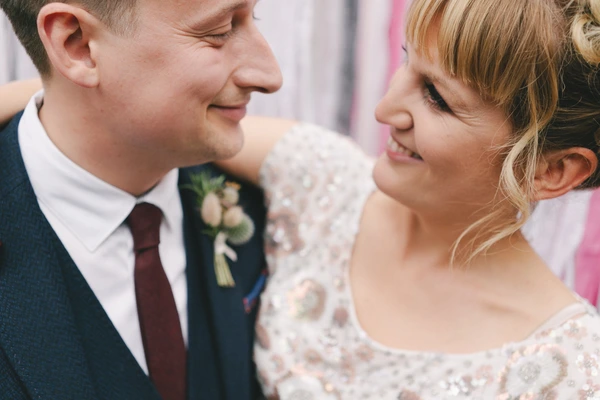 Groom and bride look lovingly at each other, both smiling — intimate moment during the ceremony