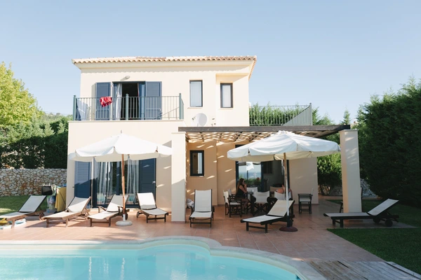 Mediterranean villa with pool, terrace, white umbrellas, sun loungers and a relaxation zone