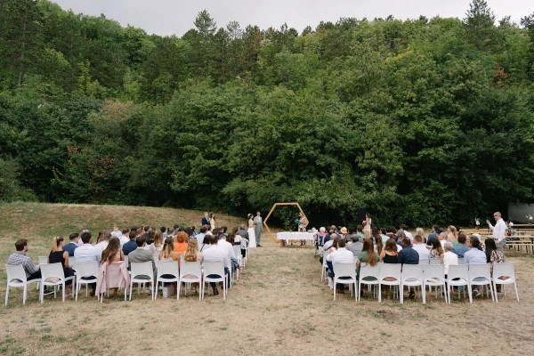 Wide angle shot of the wedding ceremony at Pál-völgyi Barlang, showing the entire wedding crowds and the unique forest setting.