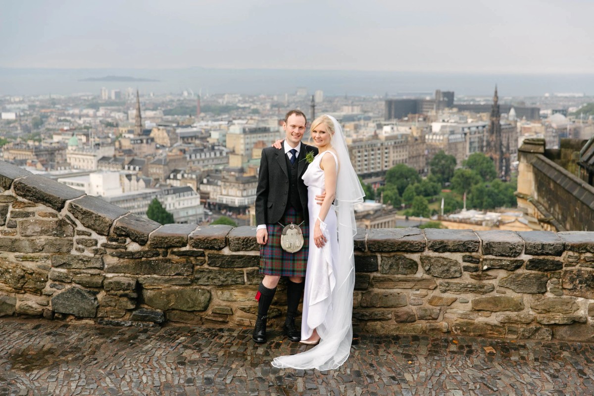 Bride and groom photographed in the Edinburgh Castle with the New Town as backdrop behind them