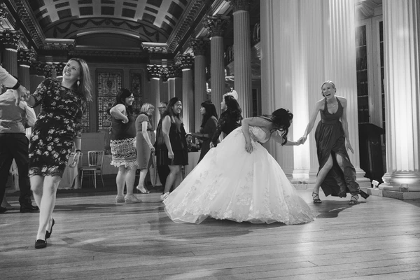 Bride dances on a baroque terrace with high columns — black-and-white, warmth and joy