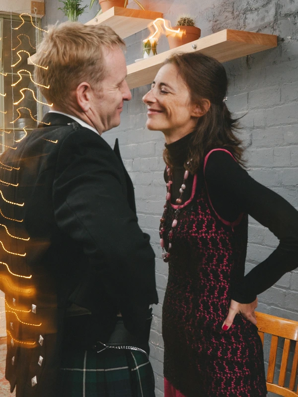 Man and woman smiling at each other in a modern loft — gold LED decoration, grey brick wall