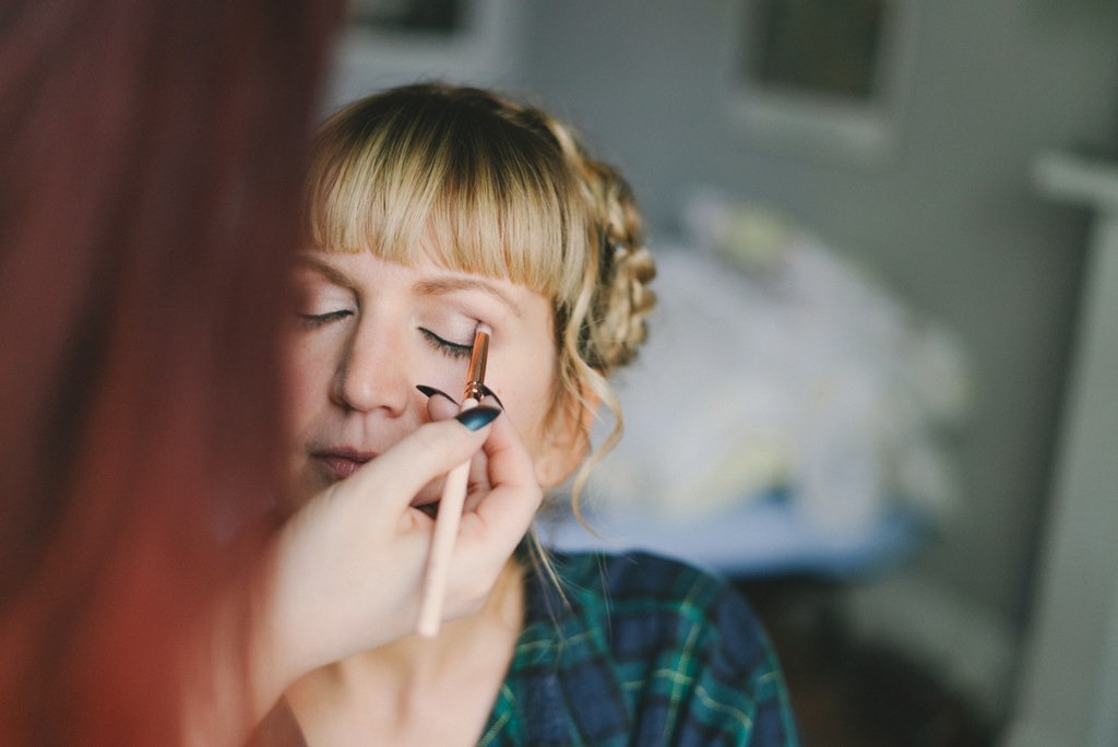 Bride's makeup final touches before the ceremony, blue eyeshadow, face in natural light