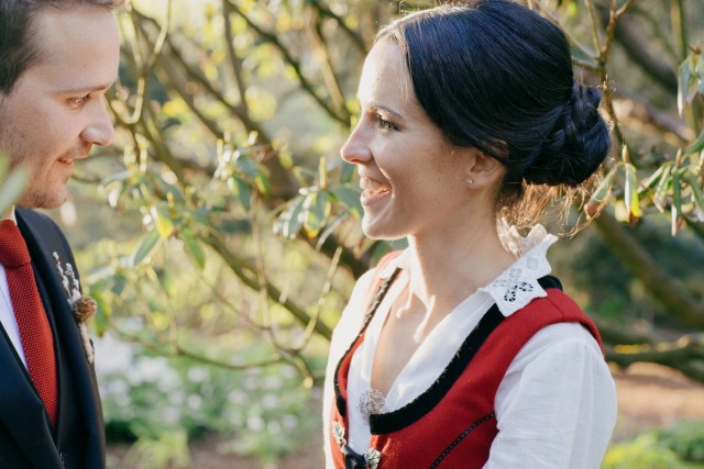 Smiling bride and groom share a joyful moment outdoors in soft golden light.