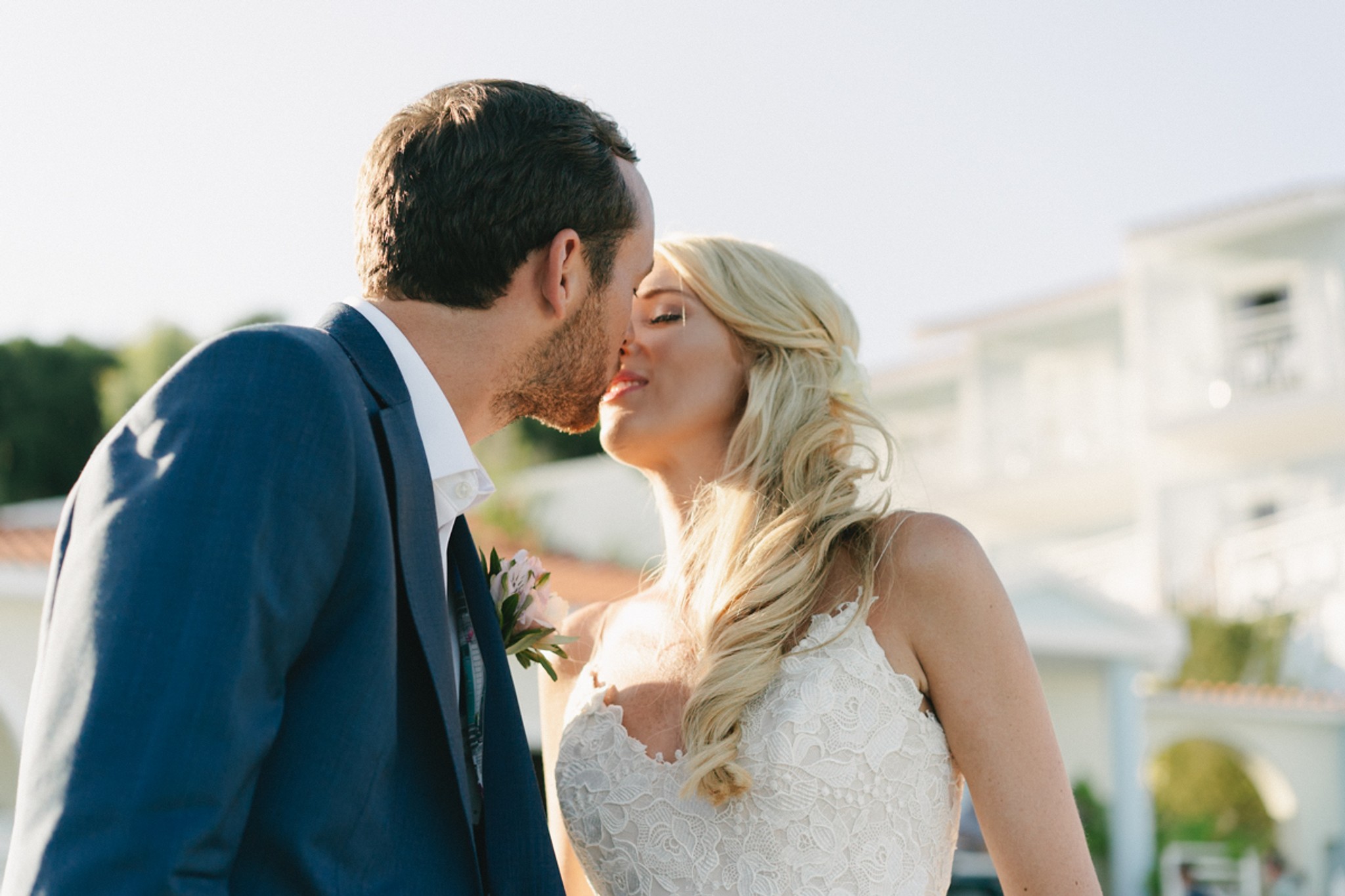 A candid wedding moment of a couple hugging and kissing unaware of the camera