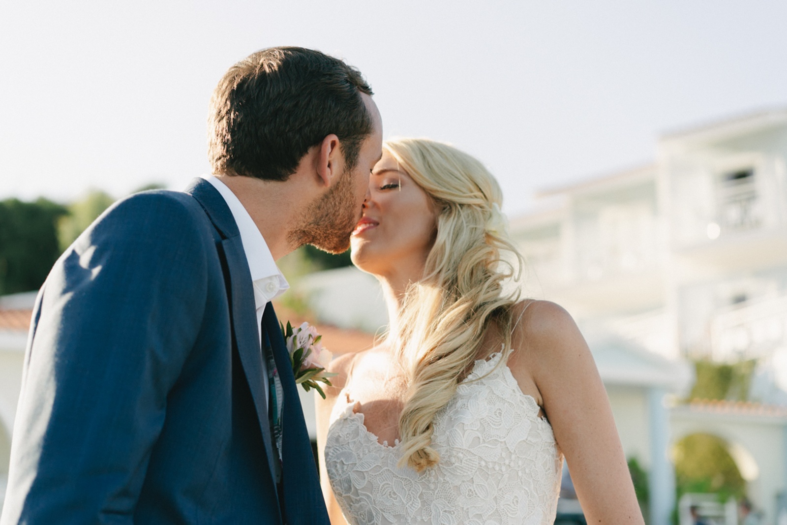 A candid wedding moment of a couple hugging and kissing unaware of the camera