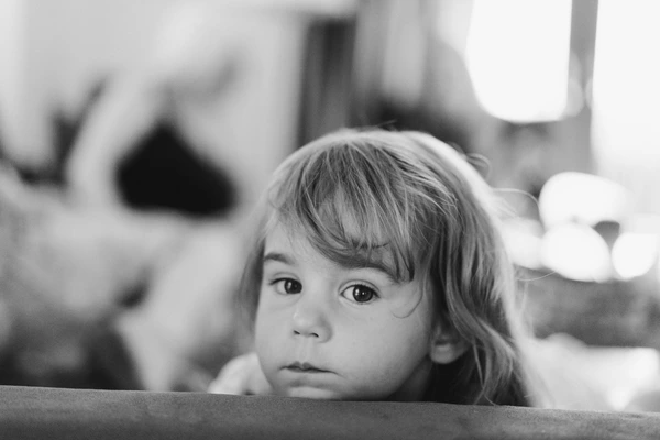Little girl with a fringe looks directly into the camera — black-and-white portrait, ceremony