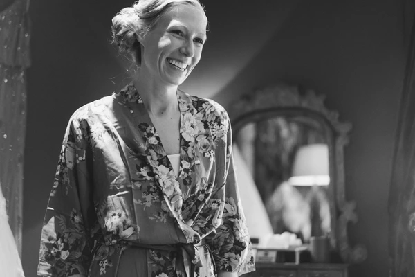 Woman in floral kimono with a serene smile, looking sideways — black-and-white portrait
