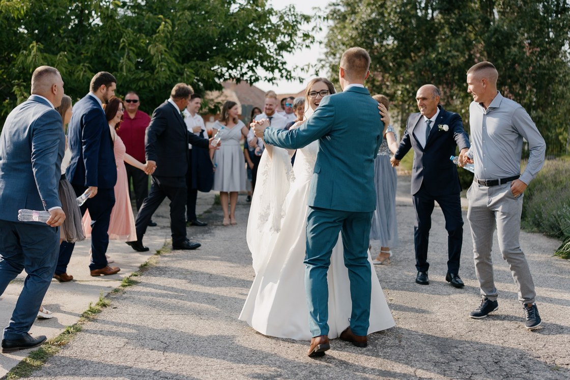 Documentary wedding photography in Hungary - newlyweds dancing on street surrounded by relatives