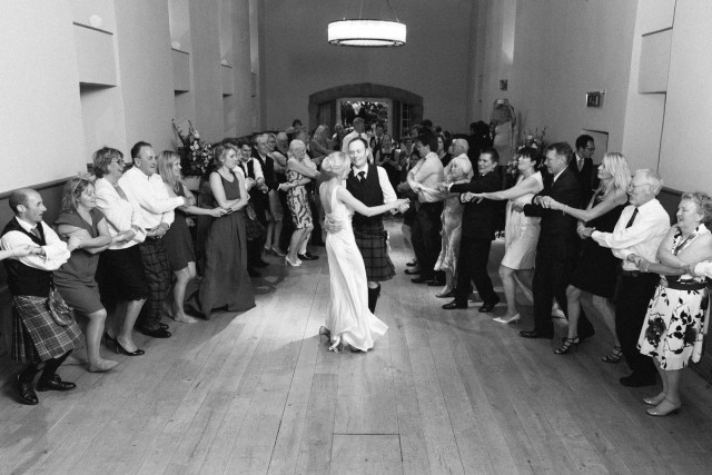 First dance at Edinburgh Castle wedding, black and white photograph of the bride and groom in the center surrounded by family and friends 