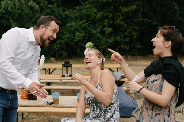 Wedding guests chatting and laughing at an outdoor reception.