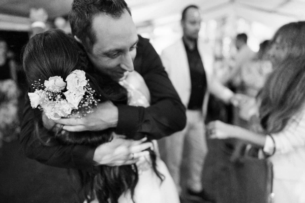 Newlyweds kiss passionately at wedding celebration — warm evening light, intimate moment, joyful reception atmosphere.