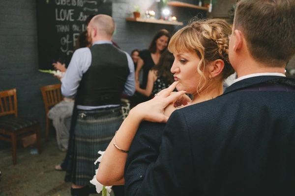 Woman with braided hair dances next to a man at the wedding — pensive moment in dark interiors
