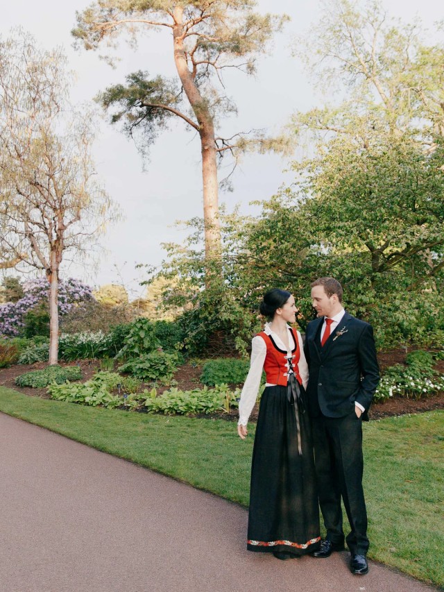 Wedding couple share a tender look in lush garden at golden hour in the Royal Botanic Garden, Edinburgh.