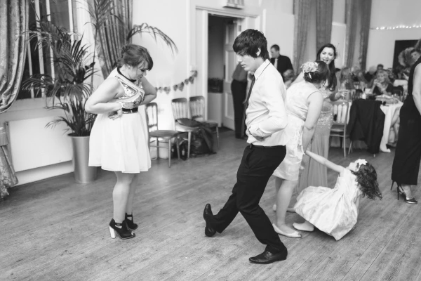 The bride in her Norwegian bunad laughs openly with pure joy at the wedding reception. Candid documentary wedding portrait.