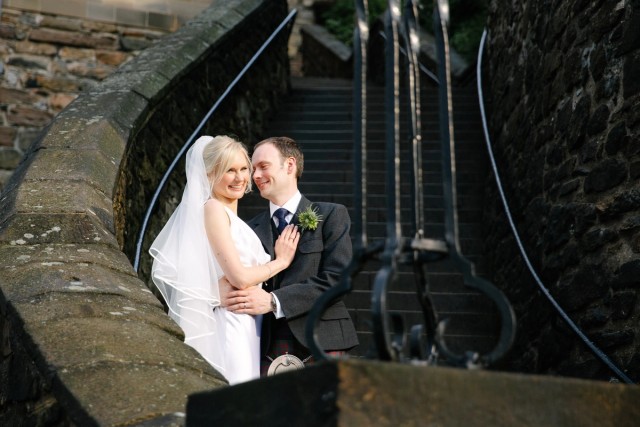Bride and groom in front of Edinburgh Castle stairs after thir wedding vows