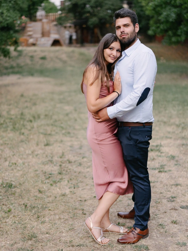Woman and man embracing with tender expression at outdoor garden wedding with natural background.