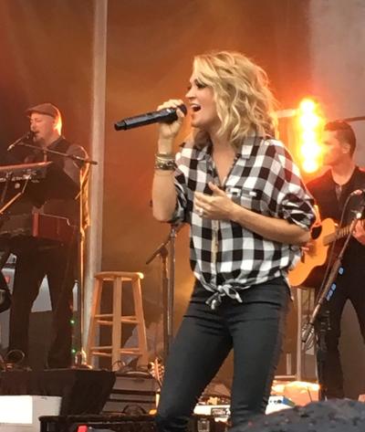 Celebrity singer Carrie Underwood performing on stage with a band, booked by a celebrity talent booking agency in Atlanta.