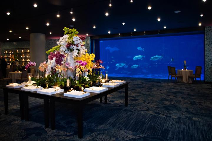 Event production Atlanta: Food station setup at a private event with dramatic floral décor in the Georgia Aquarium’s Oceans Ballroom.