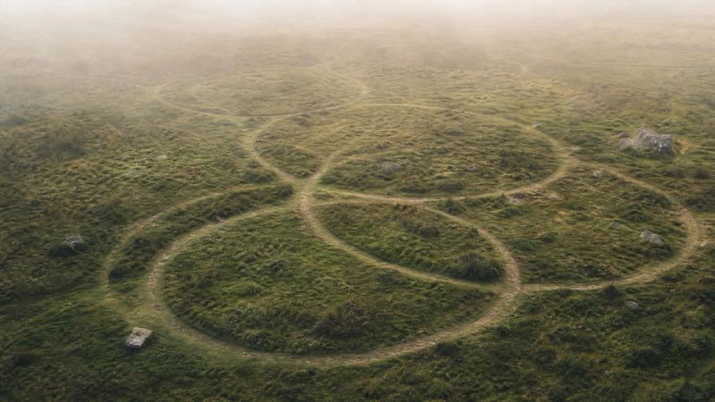 Abstract overlapping circles and loops in a calm Irish landscape, symbolising recurring OCD obsessions and compulsions