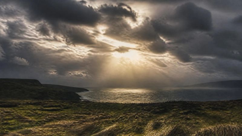A stormy Irish sky with soft light breaking through clouds, symbolising menopause mood swings
