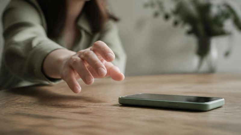 A hand reaching for a phone to call for support, representing when to seek help