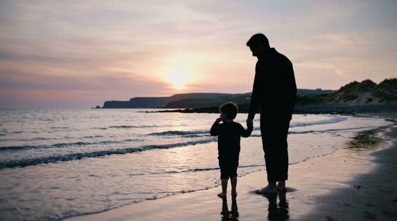 Adult and child silhouette on Irish beach at sunset, representing childhood trauma healing