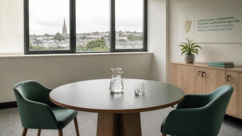 A bright meeting room with a round table and two chairs, neutral and calm
