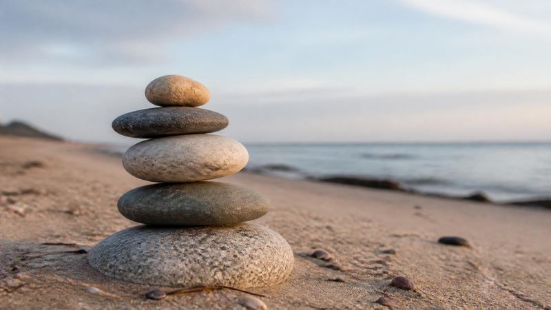 A balanced stack of stones on a beach, symbolising weighing HRT risks and benefits
