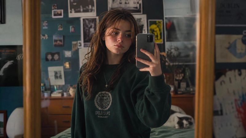 A young person posing and taking multiple photos to get the perfect shot