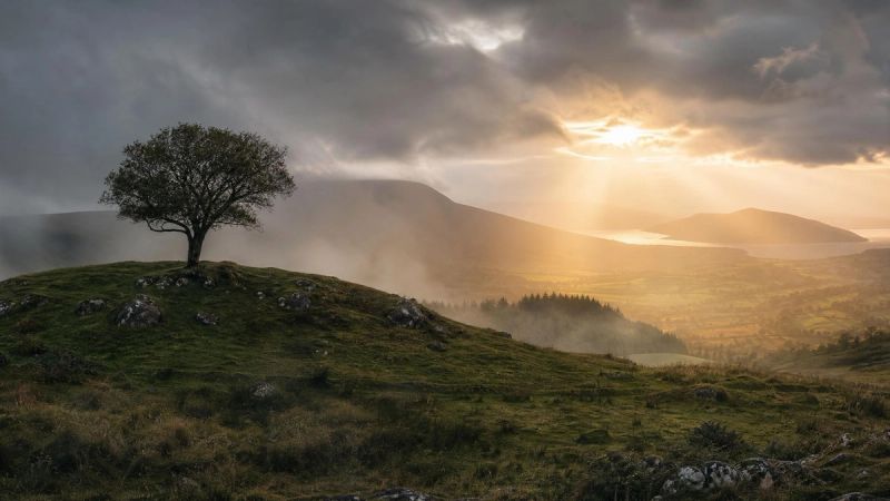 Misty Irish landscape with sunlight breaking through clouds, symbolising delayed PTSD symptoms