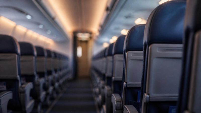 Abstract view of an airplane cabin aisle from above, representing the enclosed space of flying