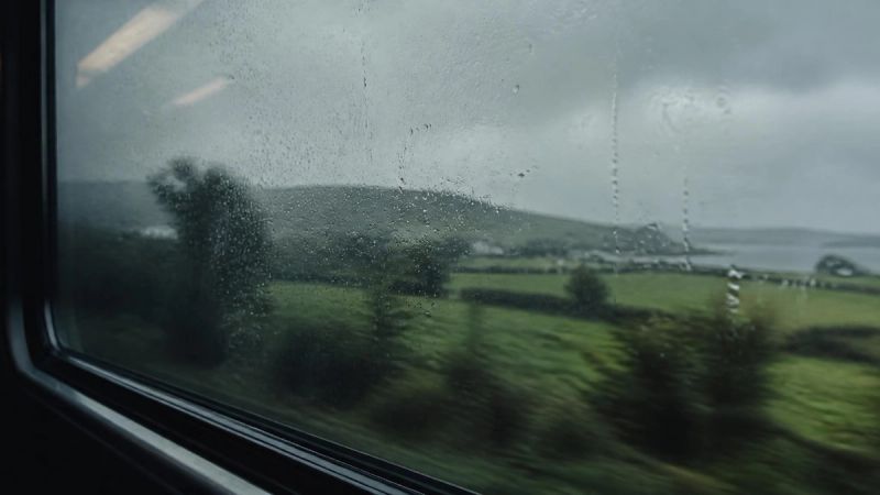 A rainy Irish commute seen through a window, reflecting daily pressures.