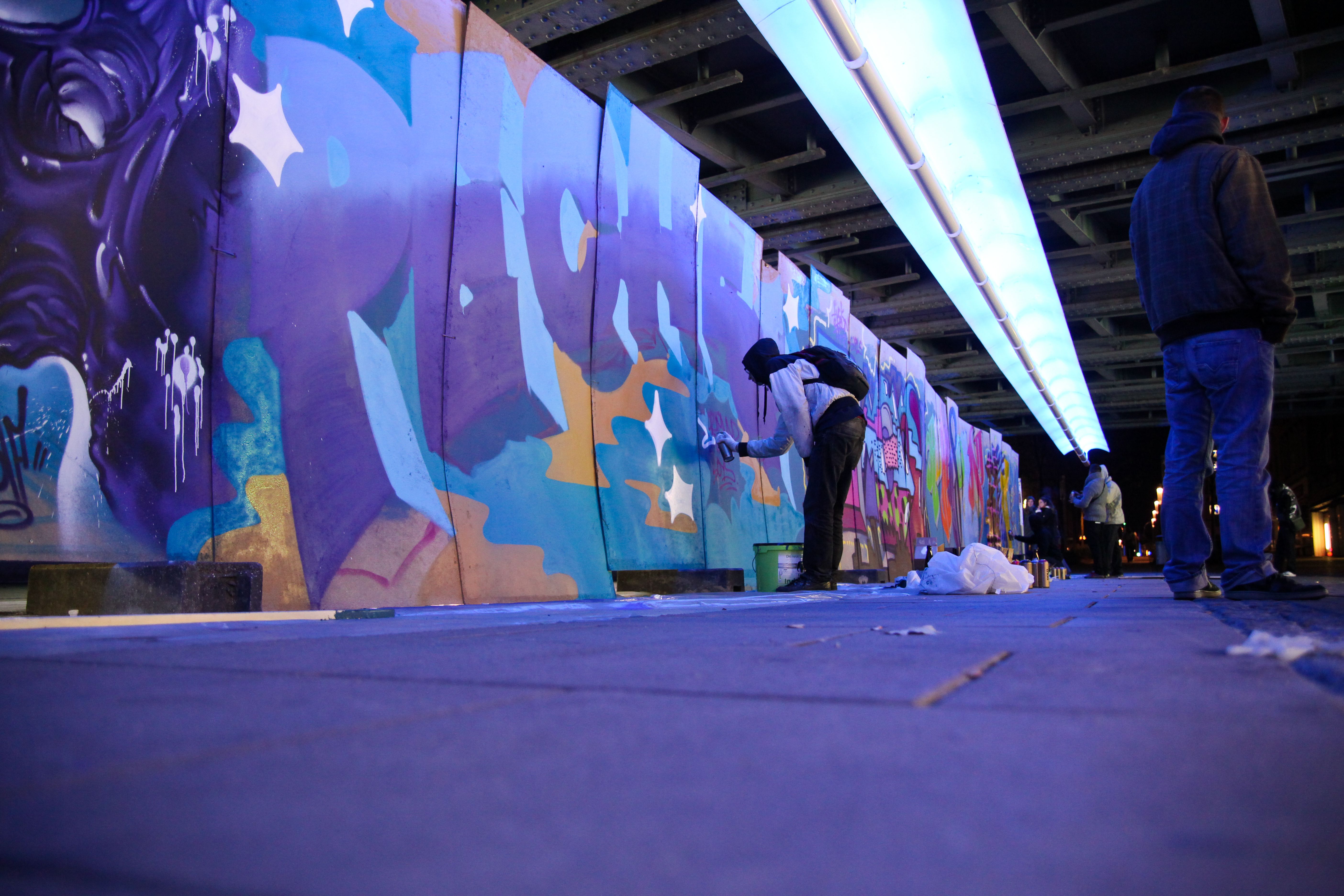 Zu sehen ist eine Person beim malen eines Graffitis.