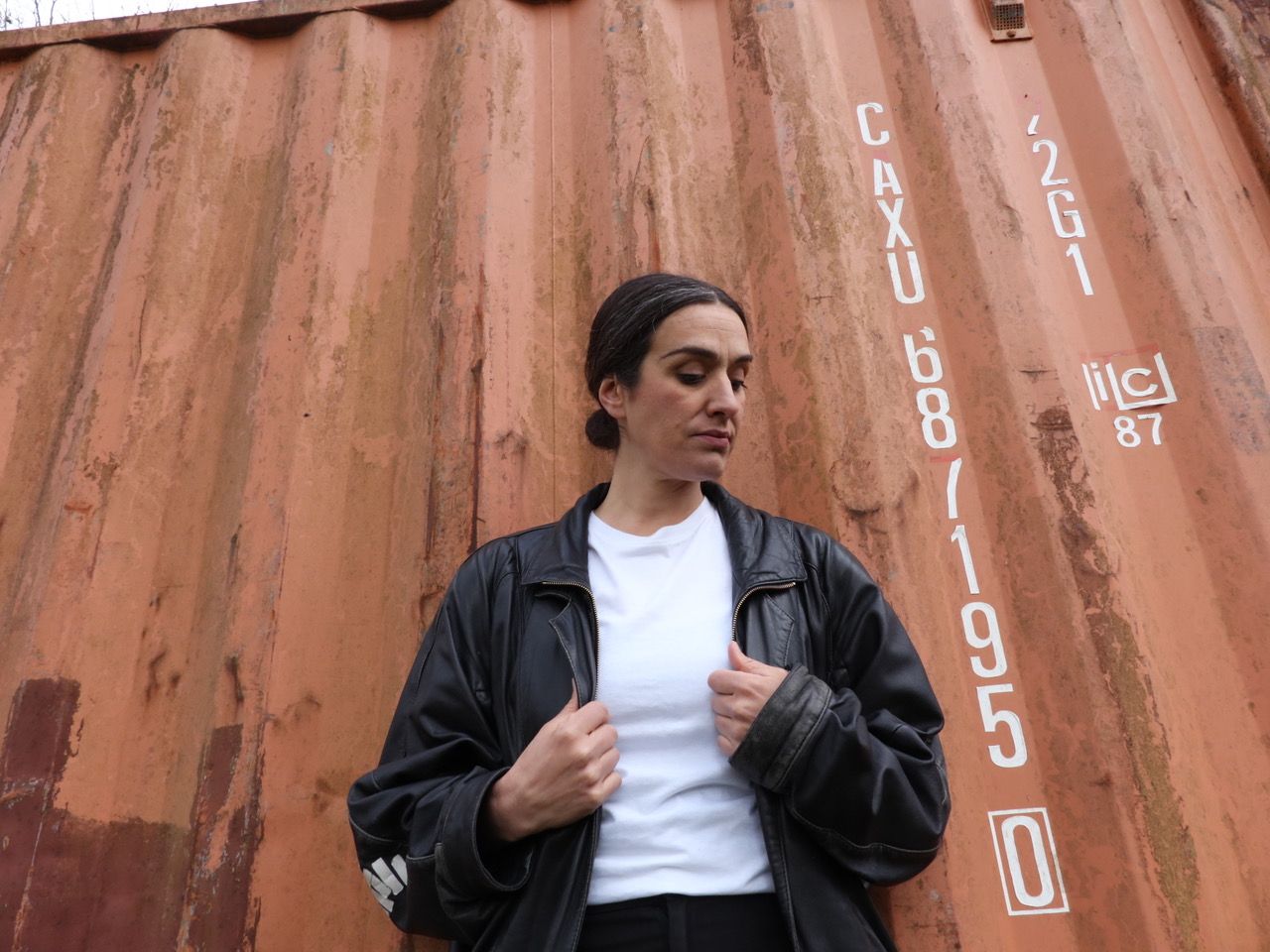 Profilbild einer Person, die vor einem Container steht