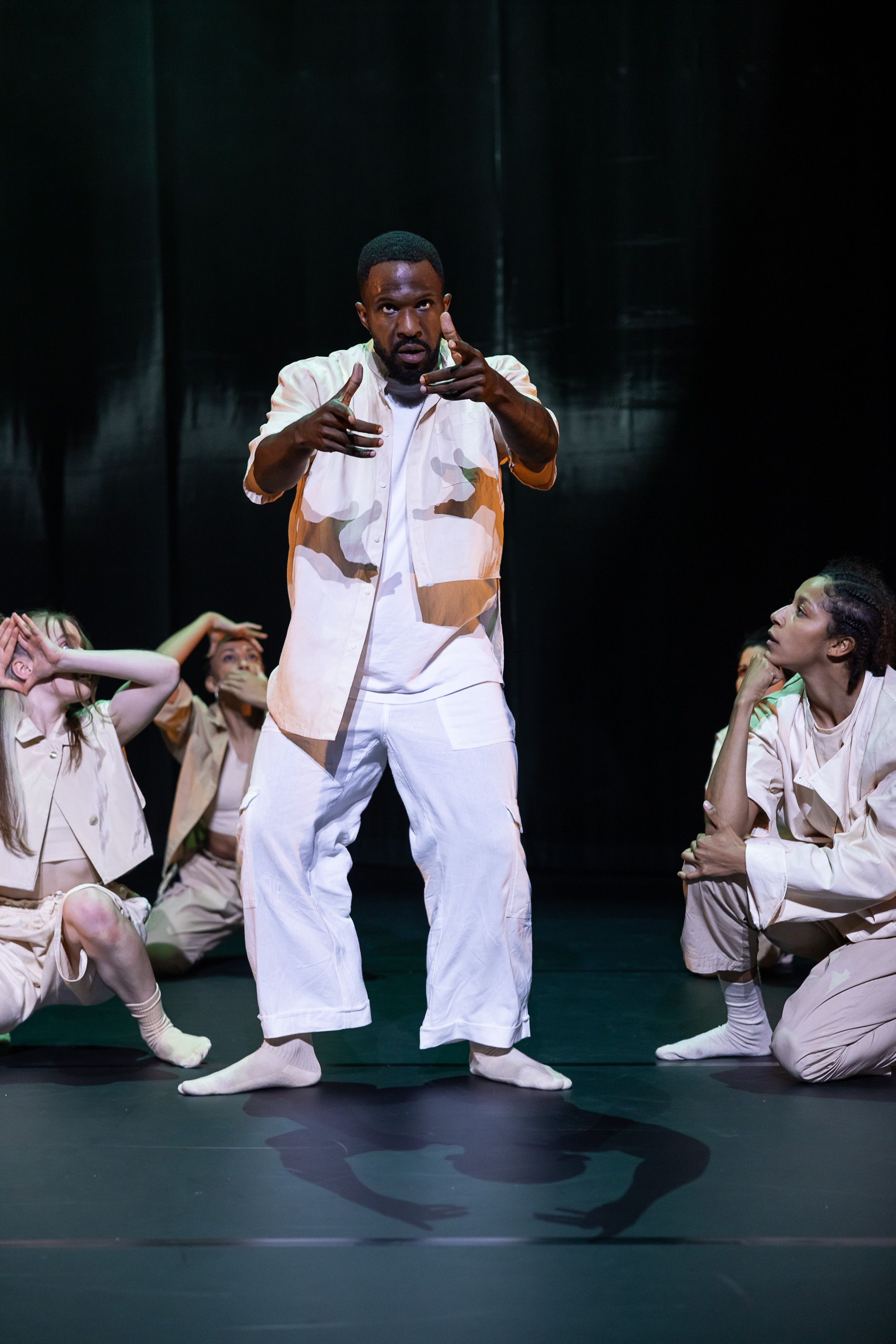 Ein Tänzer auf der Bühne umgeben von anderen