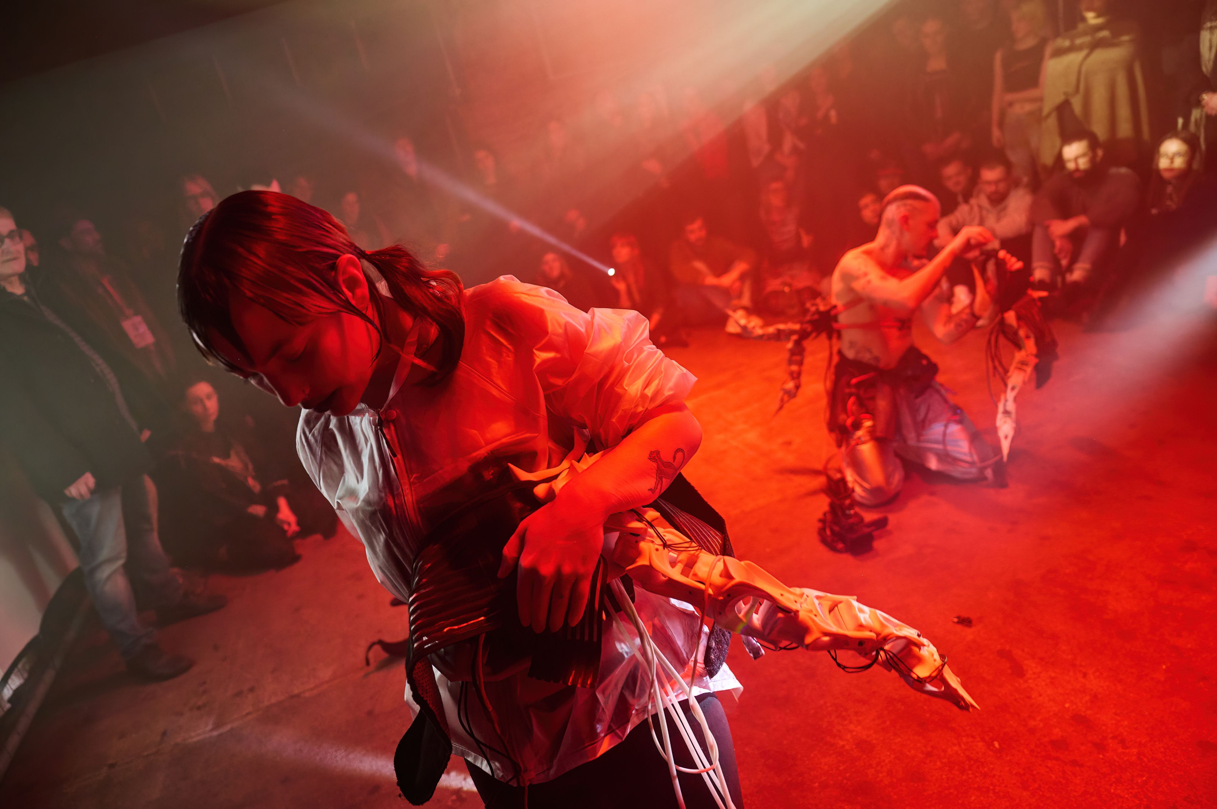 zwei Personen auf der Bühne, Publikum sitzt im Kreis darum herum